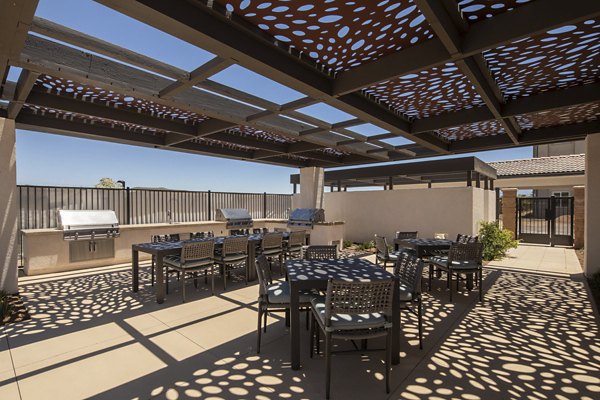 Grill area with modern seating at Delhaven Pointe Apartments patio, ideal for outdoor dining and relaxation