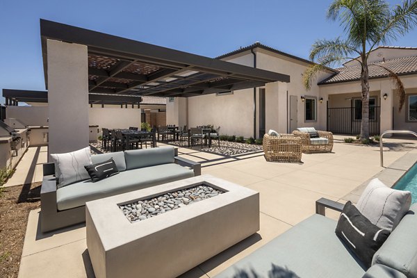 Cozy fire pit on modern patio at Delhaven Pointe Apartments