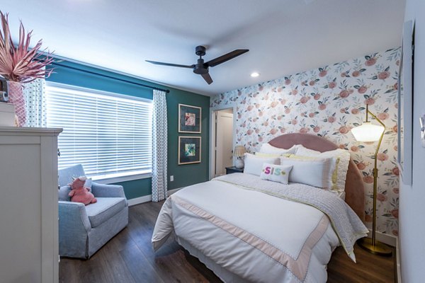 Elegant bedroom with modern decor and large windows at Eden at Sunterra Apartments