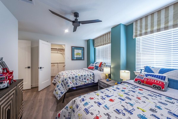 Cozy bedroom with ample natural light at Eden at Sunterra Apartments, offering luxury living spaces