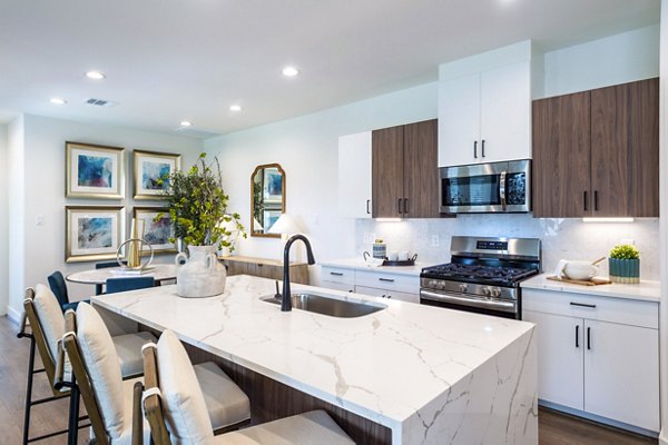 Modern kitchen with stainless steel appliances in Eden at Sunterra Apartments