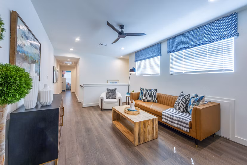 Modern living room with chic decor and large windows at Eden at Sunterra Apartments, ideal for luxury living and relaxation