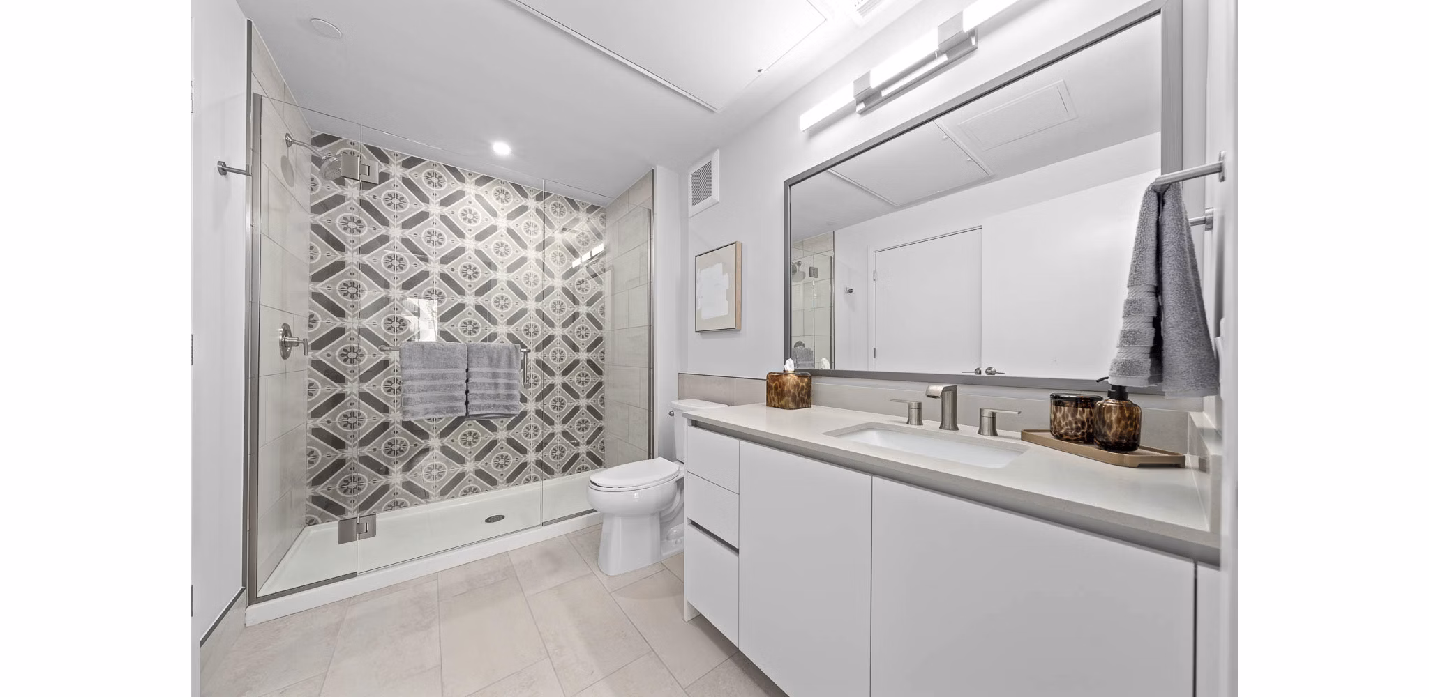 Modern bathroom with marble countertops and large mirror in The Monde Scottsdale Apartments