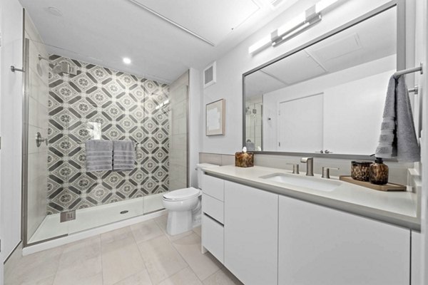 Modern bathroom with marble countertops and large mirror in The Monde Scottsdale Apartments