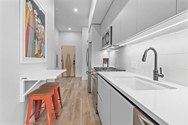 Modern kitchen with stainless steel appliances and granite countertops at The Monde Scottsdale Apartments