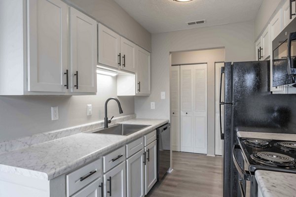 Modern kitchen with stainless steel appliances at The M Club Apartments