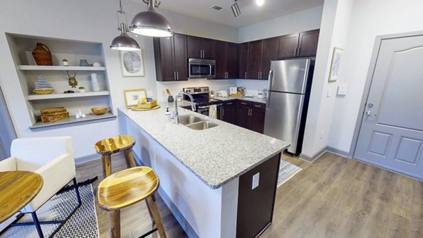 Modern kitchen with stainless steel appliances at Indigo at Cross Creek Apartments