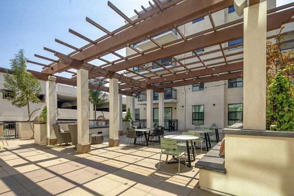 Outdoor grill area with modern patio furniture at Lumia Apartments