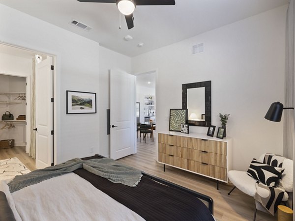 Cozy bedroom with large windows at The Evergrove at Crystal Village Apartments, offering comfort and style in a luxurious setting