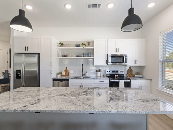 Kitchens with granite countertops and modern appliances in The Evergrove at Crystal Village Apartments