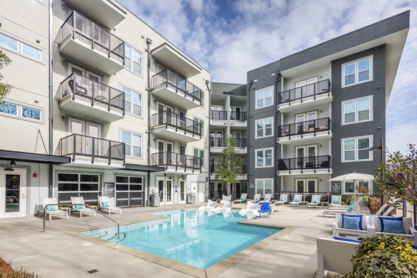 Outdoor pool with sun loungers at The Gibson Apartments, offering luxury amenities and leisure spaces for residents