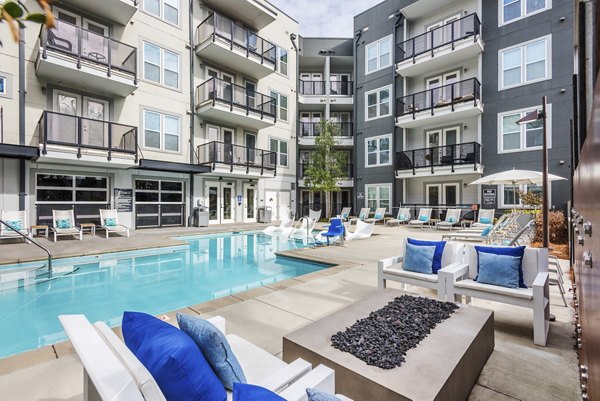 Luxurious outdoor pool with lounge chairs at The Gibson Apartments, providing a perfect relaxation spot for residents