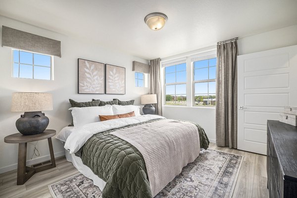 Cozy bedroom with modern furnishings at The Cottages at Erie Commons Apartments