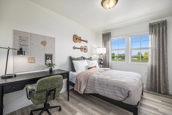 Bedroom featuring cozy decor and elegant furnishings at The Cottages at Erie Commons Apartments