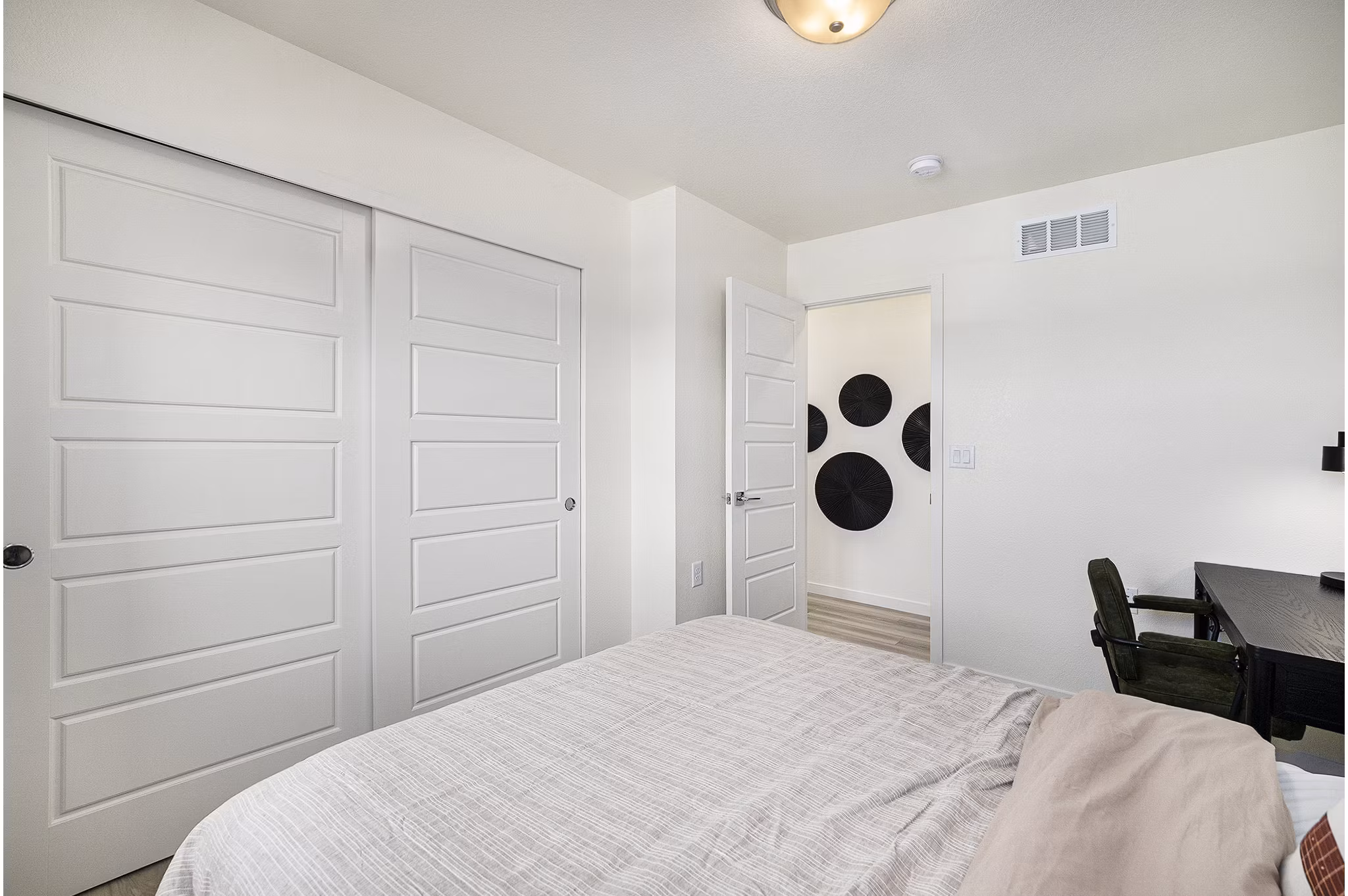Spacious bedroom featuring cozy decor at The Cottages at Erie Commons Apartments, luxury living by Greystar