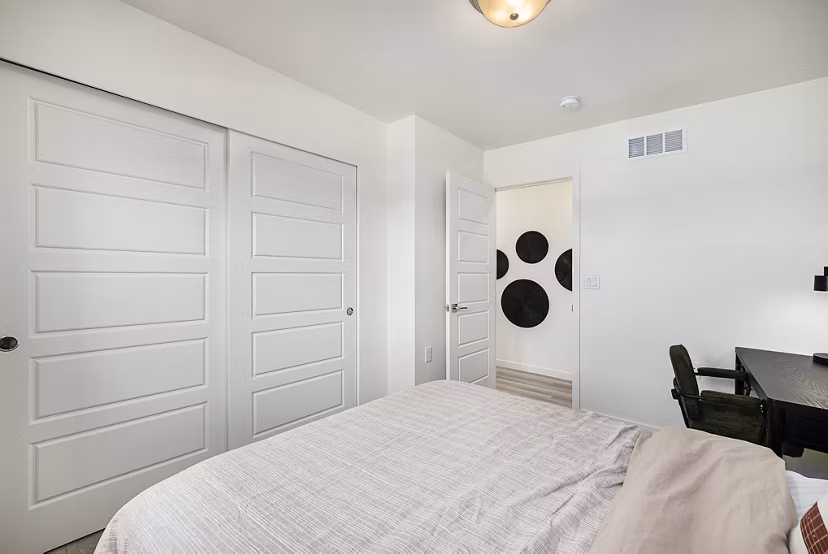Spacious bedroom featuring cozy decor at The Cottages at Erie Commons Apartments, luxury living by Greystar