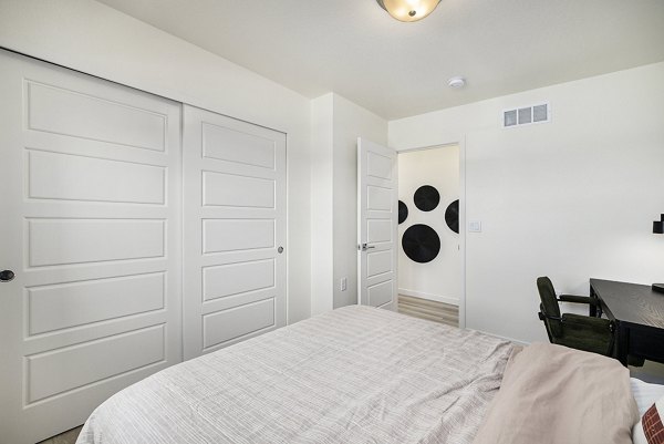 Spacious bedroom featuring cozy decor at The Cottages at Erie Commons Apartments, luxury living by Greystar