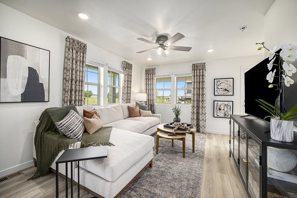 Modern living room with cozy seating and natural light at The Cottages at Erie Commons Apartments