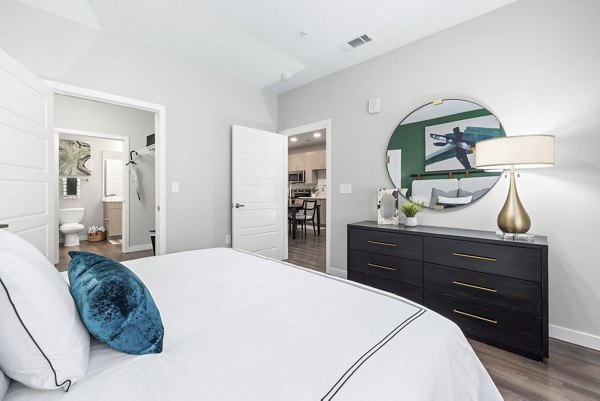 Elegant bedroom with plush bedding and large windows in Atlantic Springs Apartments
