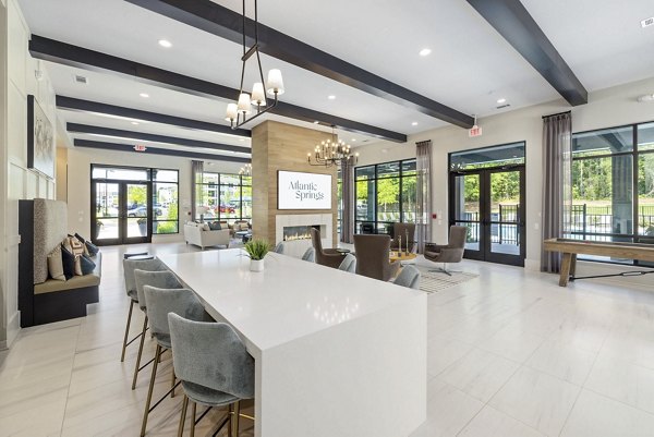 Clubhouse: Elegant event space at Atlantic Springs Apartments with modern furnishings and ambient lighting