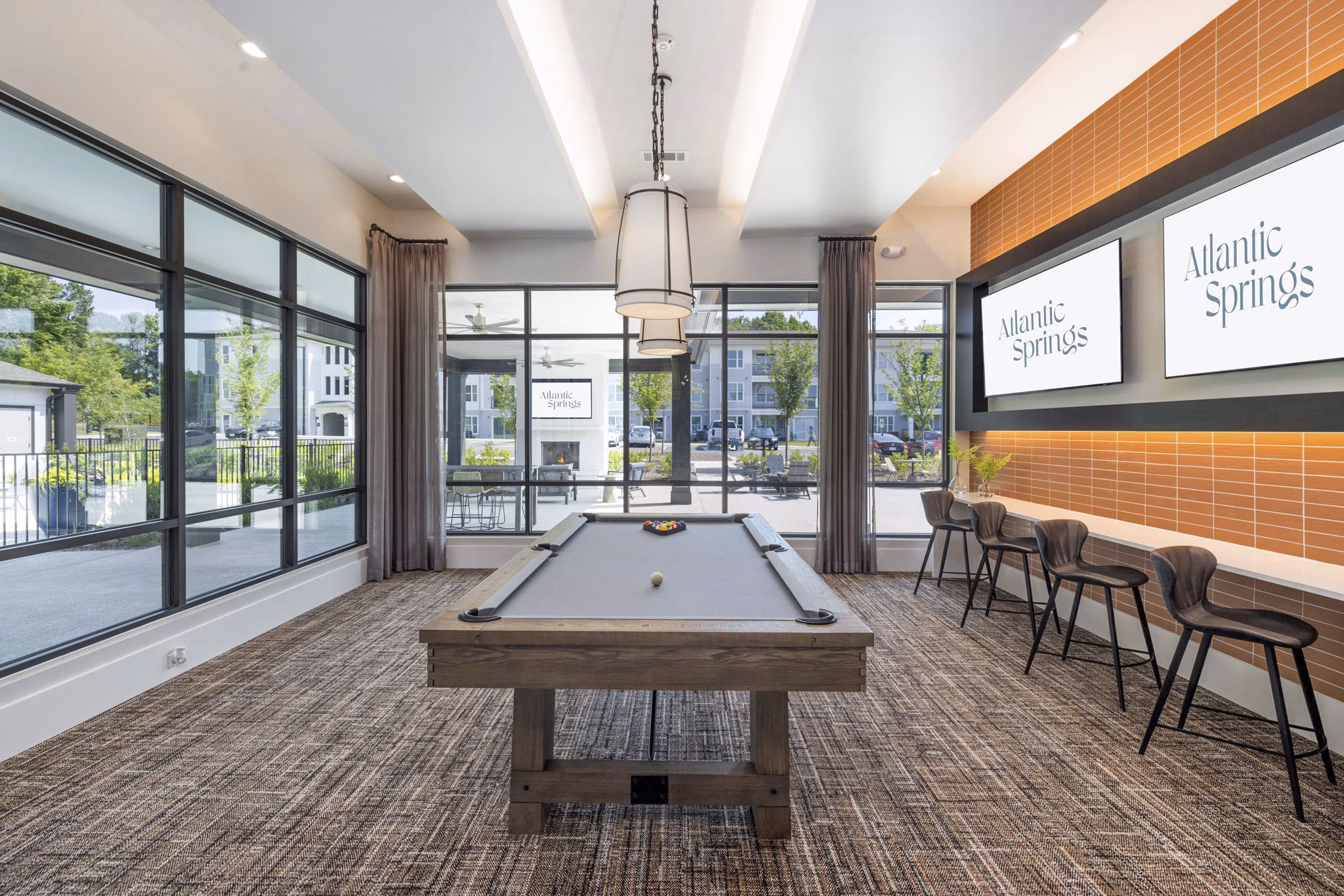 Clubhouse game room with billiards and lounge seating at Atlantic Springs Apartments, luxury community by Greystar