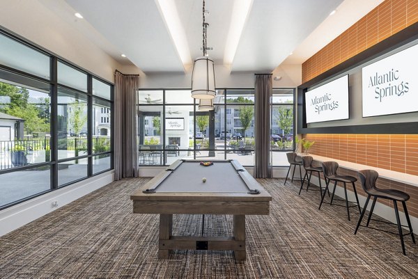 Clubhouse game room with billiards and lounge seating at Atlantic Springs Apartments, luxury community by Greystar