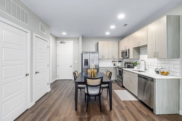 Open kitchen and dining room with modern appliances and elegant decor at Atlantic Springs Apartments, Greystar luxury community