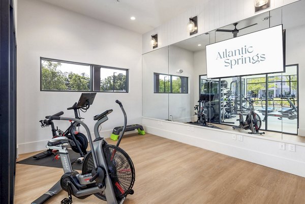 Yoga and spin studio with modern equipment at Atlantic Springs Apartments, promoting an active lifestyle within a luxury community