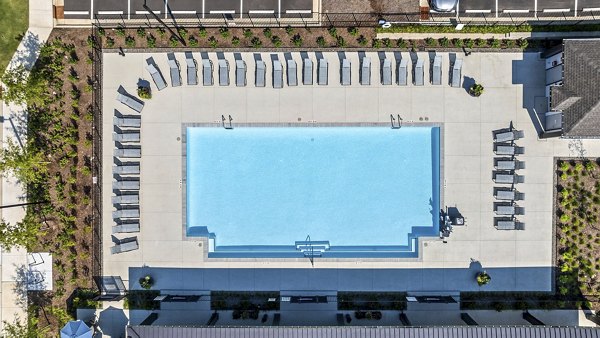 Luxurious outdoor pool at Atlantic Springs Apartments with lounge chairs and lush landscaping
