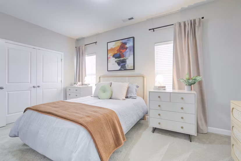 Cozy bedroom with elegant decor in Charleston Row Townhomes, luxury apartments by Greystar