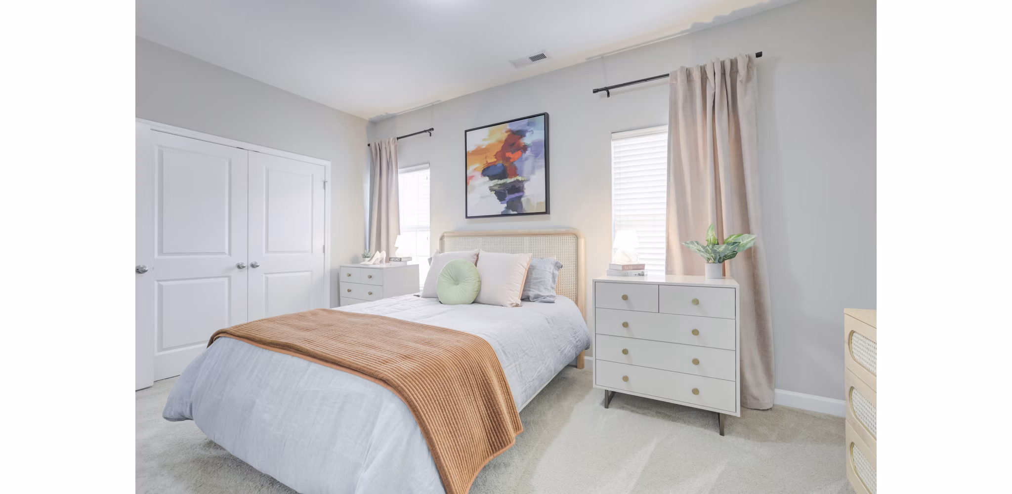 Cozy bedroom with elegant decor in Charleston Row Townhomes, luxury apartments by Greystar