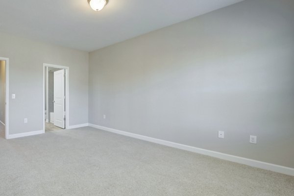 Bedroom with plush bedding and ample natural light at Charleston Row Townhomes