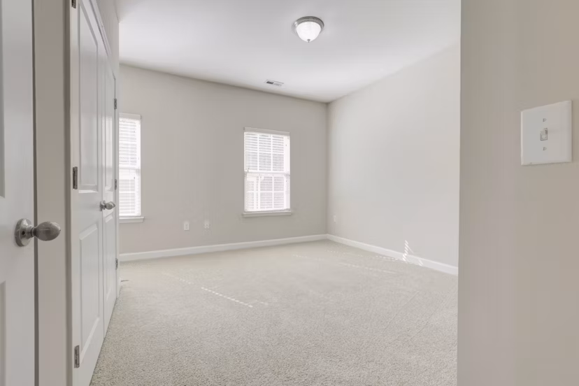 Elegant bedroom with natural light filtering through large windows at Charleston Row Townhomes, luxury apartments by Greystar