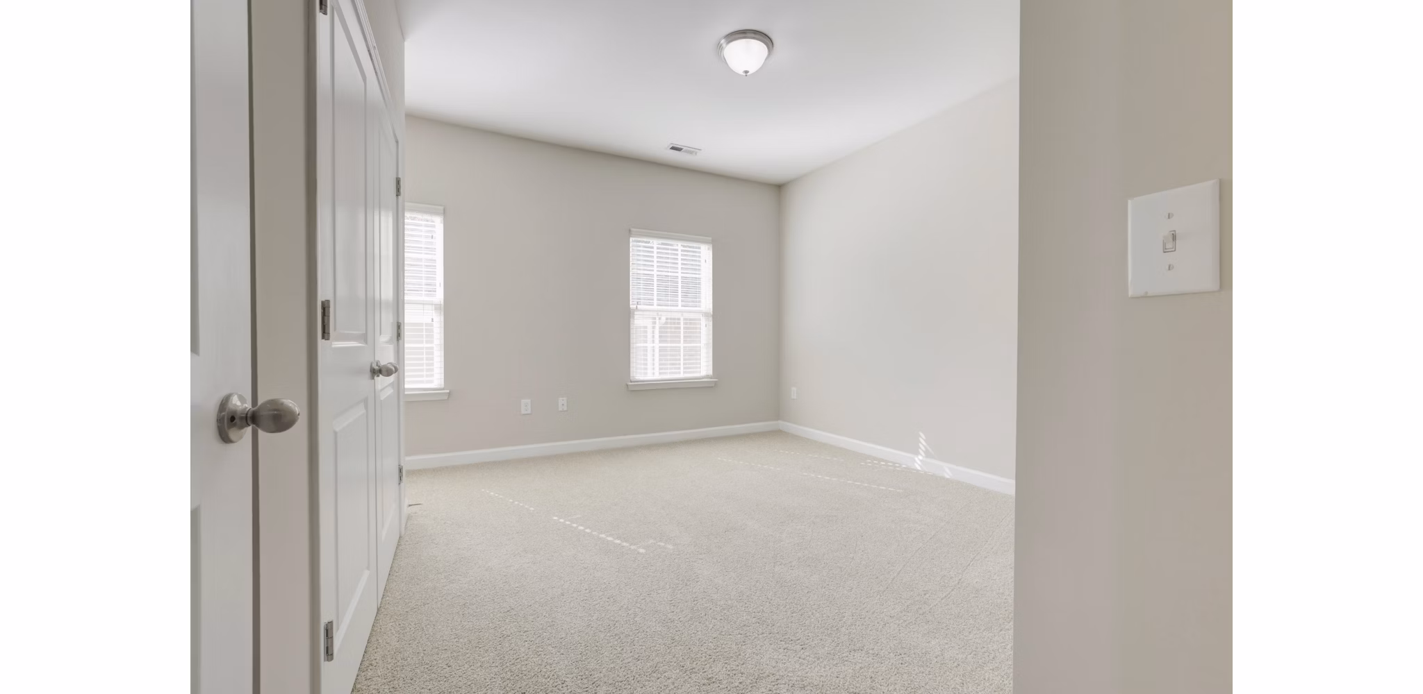 Elegant bedroom with natural light filtering through large windows at Charleston Row Townhomes, luxury apartments by Greystar