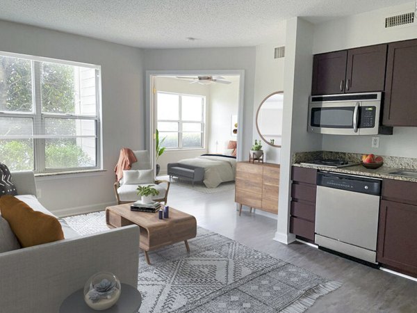 Spacious living room featuring modern decor and natural light in The Spoke at McCullough Station Apartments