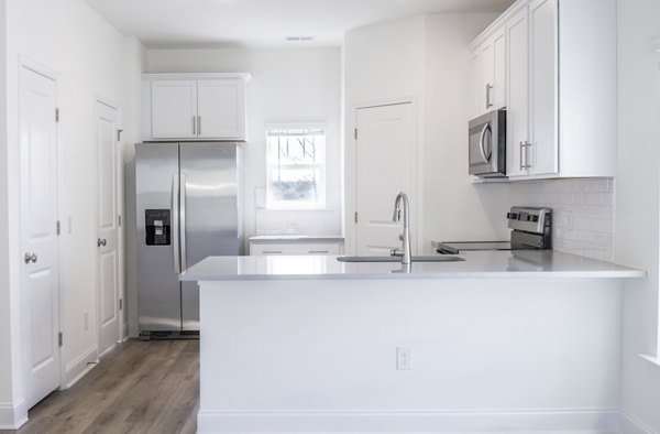 Modern kitchen with sleek cabinetry and stainless-steel appliances at Reve on the Creek Apartments