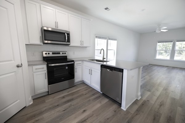 Spacious kitchen with modern appliances at Reve on the Creek Apartments, perfect for luxury living