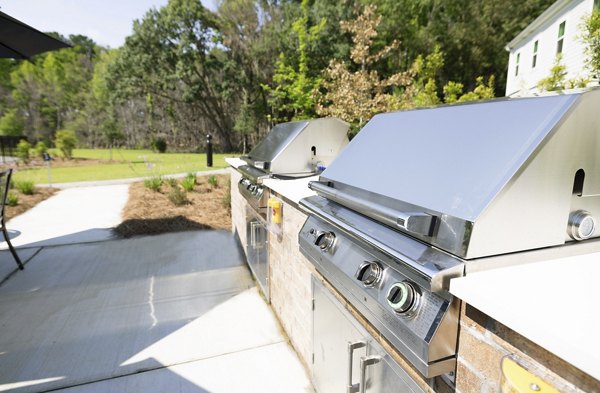 Grill and patio area with modern seating at Reve on the Creek Apartments