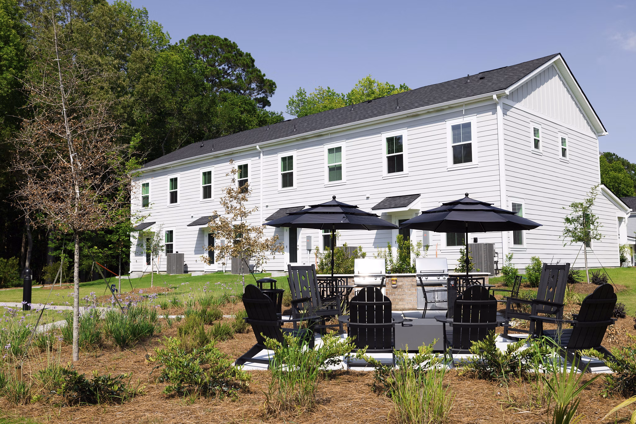 Outdoor fire pit and grill area on patio at Reve on the Creek Apartments