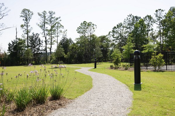 Scenic walking trail surrounded by lush greenery at Reve on the Creek Apartments, perfect for outdoor enthusiasts seeking tranquility and nature