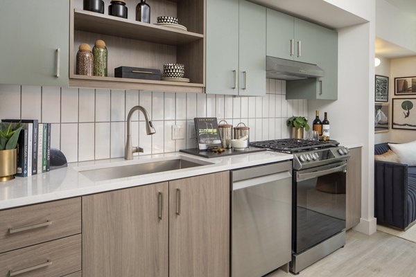 Modern kitchen with stainless steel appliances and quartz countertops at Millhouse Apartments