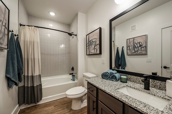 Luxurious bathroom featuring marble countertops and twin sinks at Perla Apartments