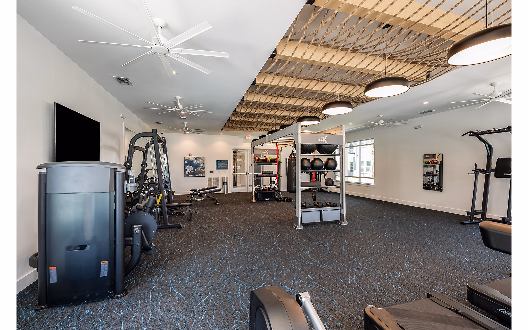 Fully-equipped fitness center featuring modern gym equipment at Perla Apartments, a luxury living community by Greystar