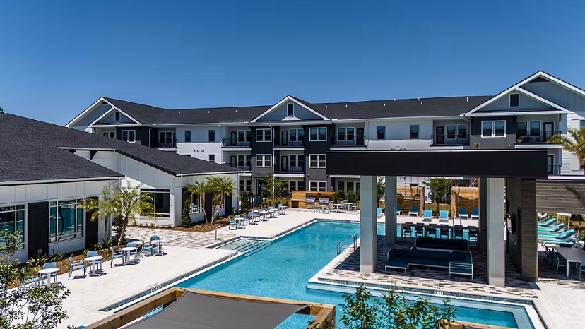 Luxurious pool with stylish lounge seating at Perla Apartments, offering a premium leisure experience