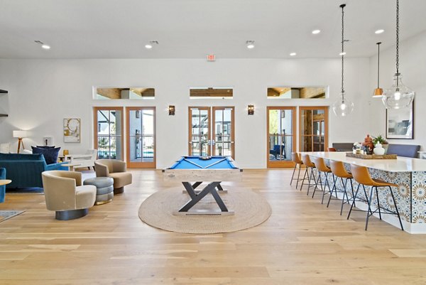 Clubhouse game room with billiards and lounge seating at Emerson at Trace Apartments, offering a luxury living experience