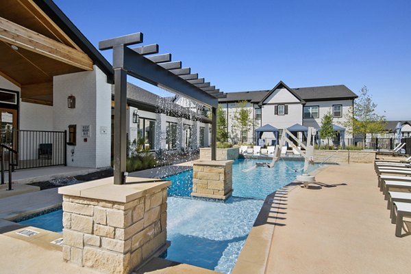 Serene outdoor pool with lounge chairs at Emerson at Trace Apartments