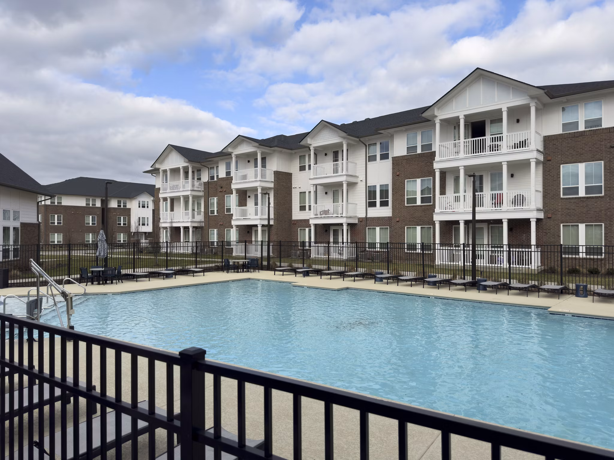 Sparkling outdoor pool with comfortable loungers at The Fitzroy at Lebanon Marketplace Apartments, offering relaxation and leisure for residents