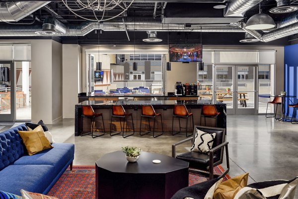 The Lofts at Westgate: Modern clubhouse with stylish seating and game area in a luxury apartment community
