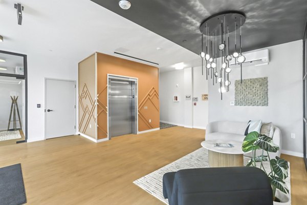 Inviting clubhouse with modern seating and a fireplace at Hudson West Apartments offering luxury and comfort for residents