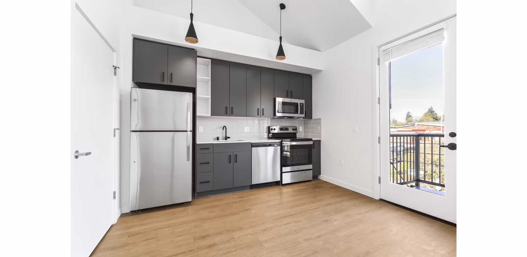 Modern kitchen with stainless steel appliances and marble countertops at Hudson West Apartments